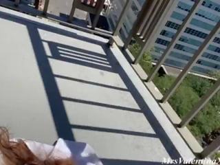 Fit brunette beauty on public balcony plays with her big boobs and shaved pussy